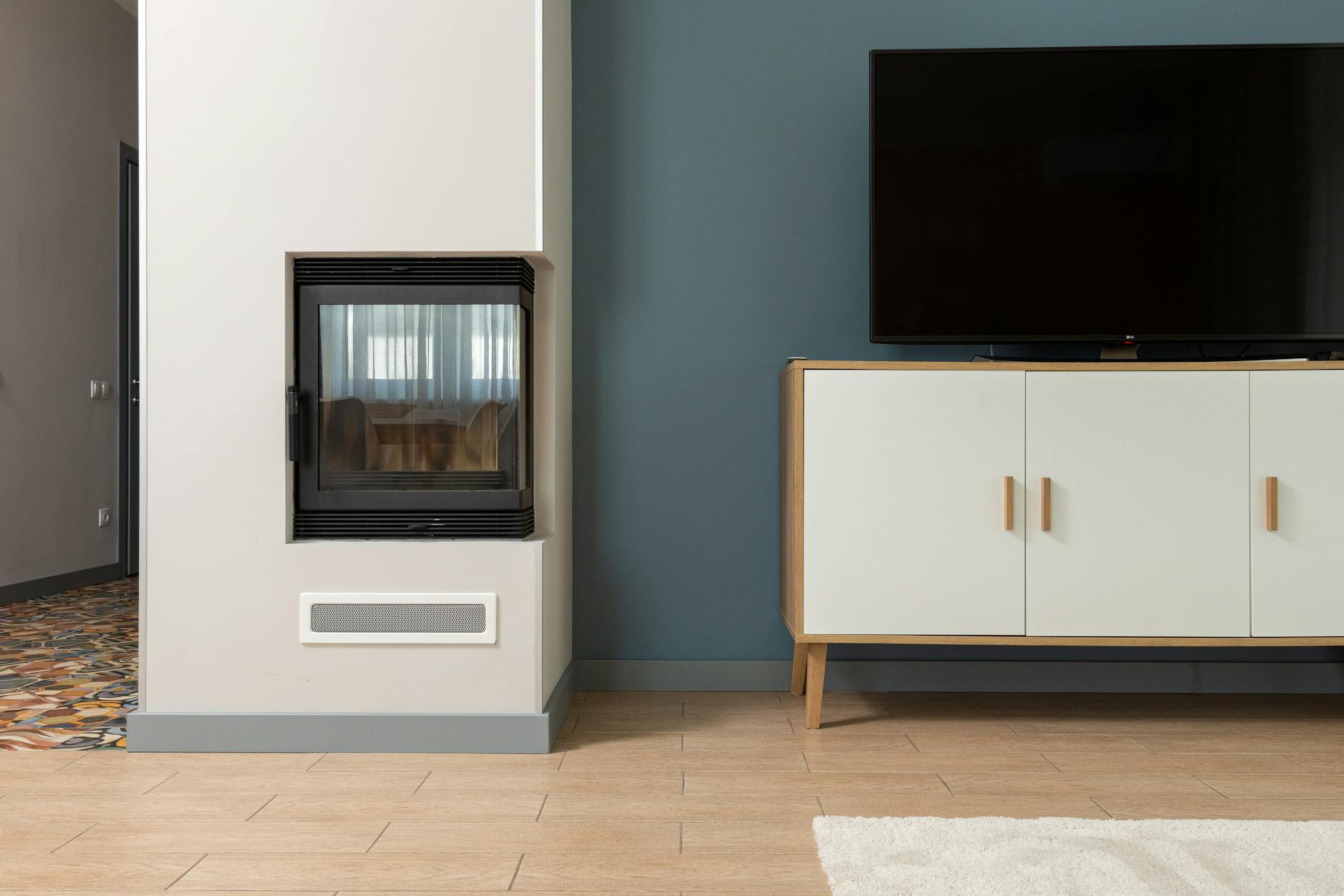 Electric fireplace next to a TV media console in a modern living room